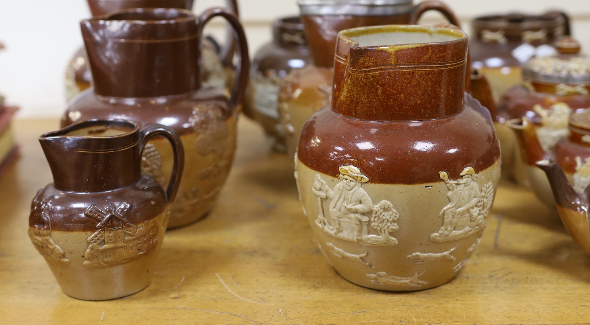 Eight various Royal Doulton Lambeth and other stoneware jugs and tea pots, one silver-mounted